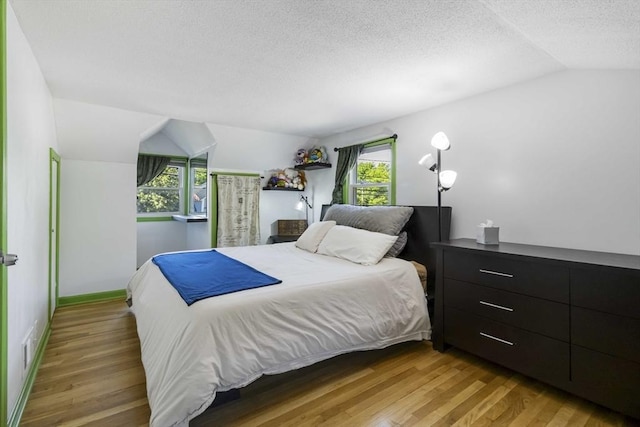 69 Powder Mill Rd, Maynard, MA 01754 - bedroom with vaulted ceiling, light wood-type flooring, and a textured ceiling