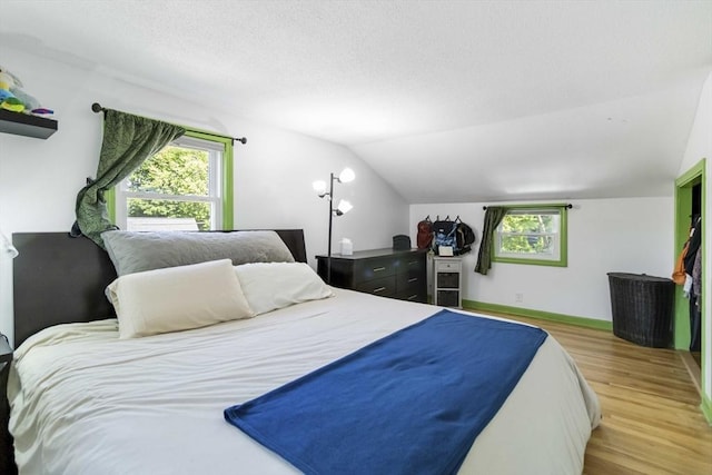 69 Powder Mill Rd, Maynard, MA 01754 - bedroom with light wood-type flooring, lofted ceiling, and a textured ceiling