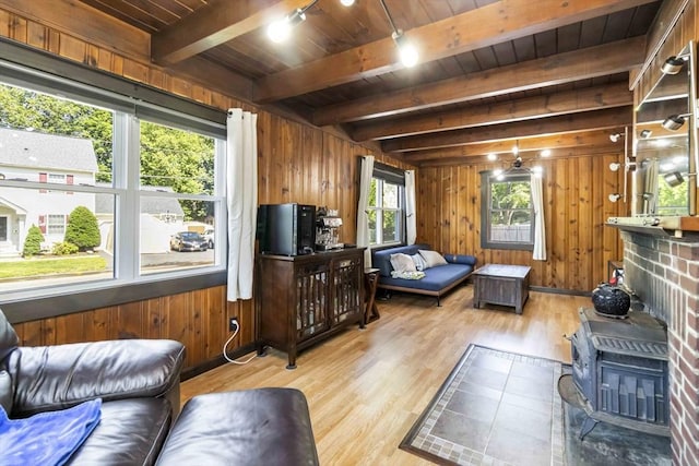 69 Powder Mill Rd, Maynard, MA 01754 - living area with light wood-style flooring, a wood ceiling with exposed beams, wood walls, and a wood stove