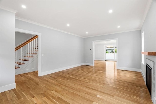 10 Whittier Rd, Natick, MA 01760 - unfurnished living room featuring stairway, a fireplace, a chandelier, light wood finished floors, and crown molding