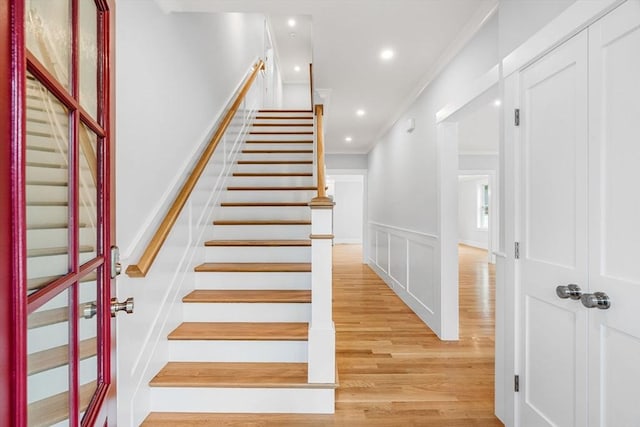 10 Whittier Rd, Natick, MA 01760 - stairs featuring ornamental molding, wood finished floors, a decorative wall, wainscoting, and recessed lighting