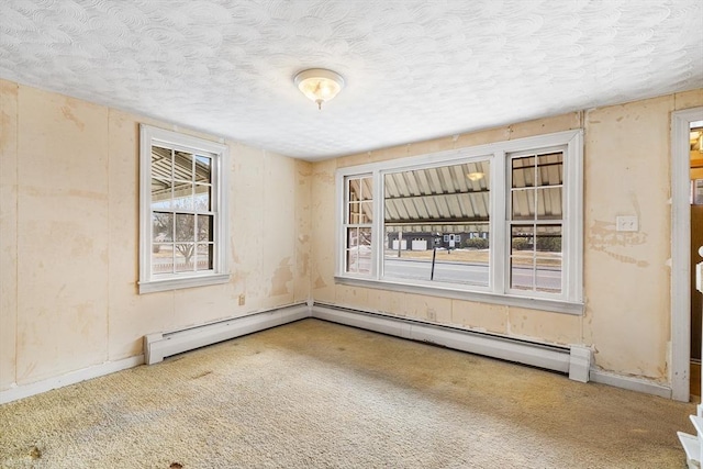 carpeted spare room with a baseboard heating unit and a textured ceiling