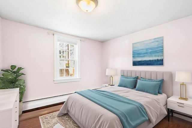 bedroom featuring a baseboard heating unit and wood finished floors