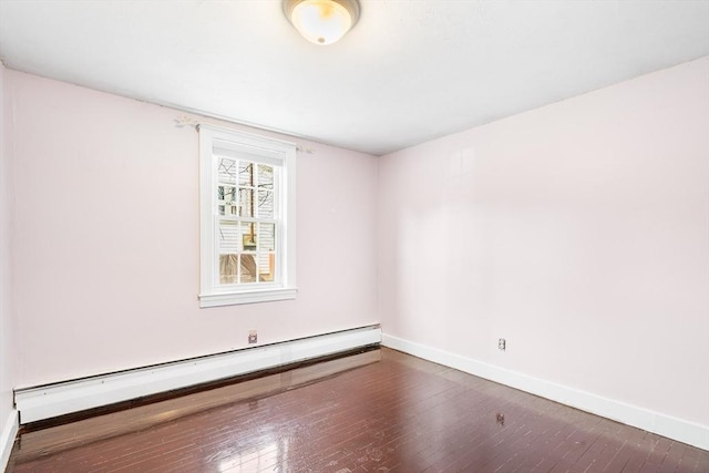 spare room featuring wood-type flooring, baseboards, and baseboard heating