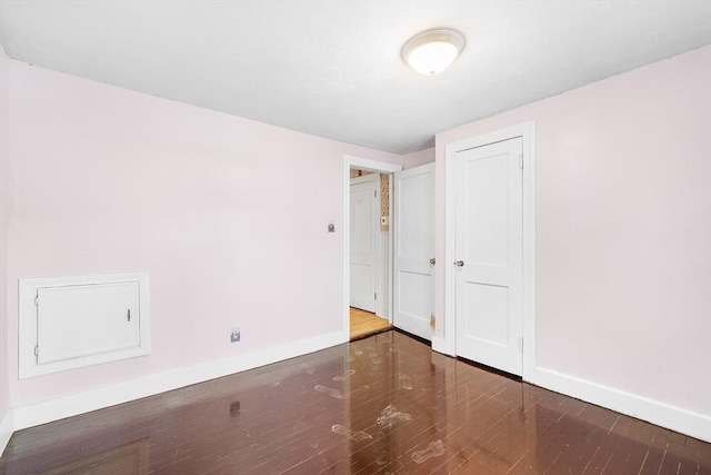 spare room with wood finished floors and baseboards