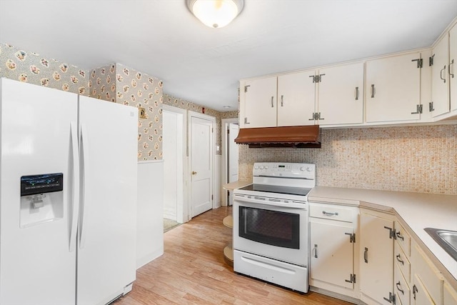 kitchen with under cabinet range hood, white appliances, light countertops, light wood-type flooring, and wallpapered walls