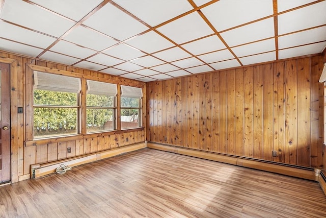 empty room featuring wooden walls and wood finished floors