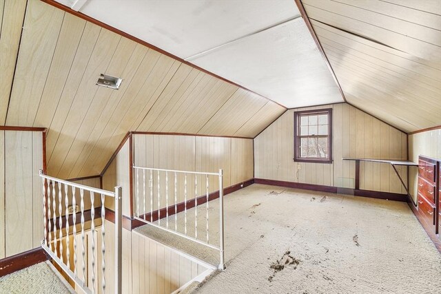 bonus room with wood walls, baseboards, vaulted ceiling, and carpet flooring