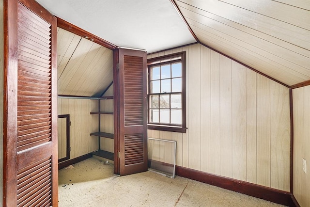 bonus room with lofted ceiling and baseboards