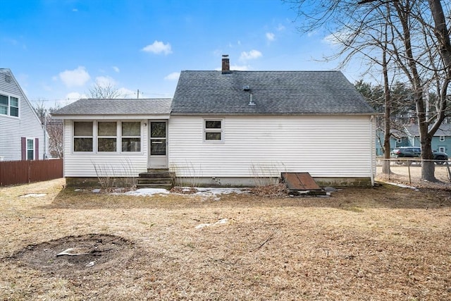 back of property featuring a shingled roof, entry steps, fence, and a chimney