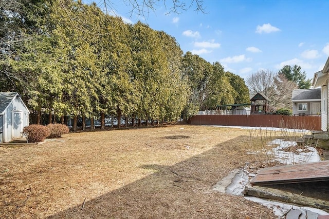 view of yard featuring a storage unit, fence, and an outdoor structure