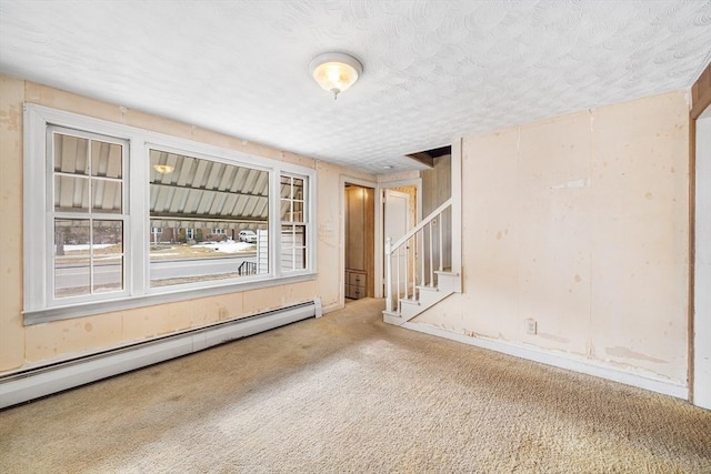 carpeted spare room with stairway, baseboard heating, and a textured ceiling