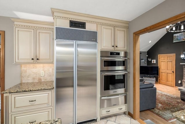 15 Wenlock Cir, Easton, MA 02356 - kitchen featuring appliances with stainless steel finishes, cream cabinetry, a warming drawer, light stone countertops, and vaulted ceiling