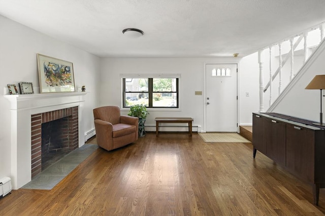 58 Edward Rd, Watertown, MA 02472 - sitting room featuring a baseboard heating unit, wood finished floors, a baseboard radiator, and stairs
