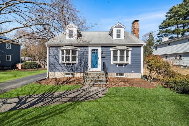 new england style home with a chimney and a front lawn