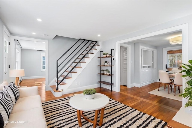 living room with stairway, recessed lighting, and wood finished floors