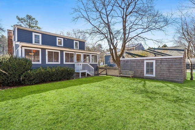 back of house with a lawn, a chimney, and fence