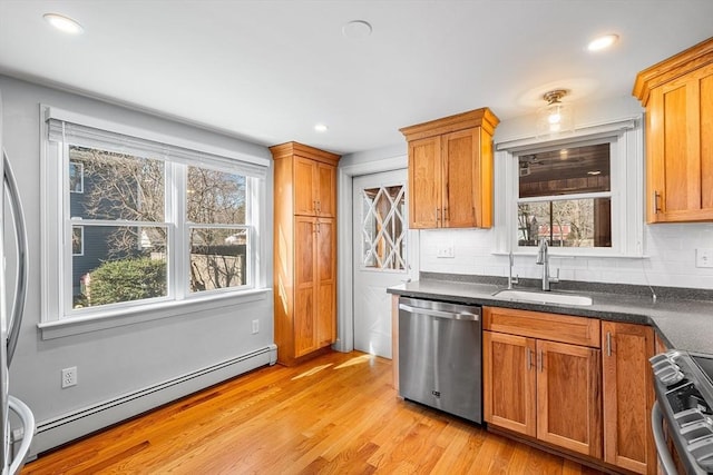 kitchen with light wood finished floors, a sink, baseboard heating, stainless steel dishwasher, and range