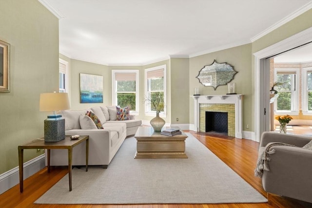 living area featuring a fireplace with flush hearth, wood finished floors, and a healthy amount of sunlight