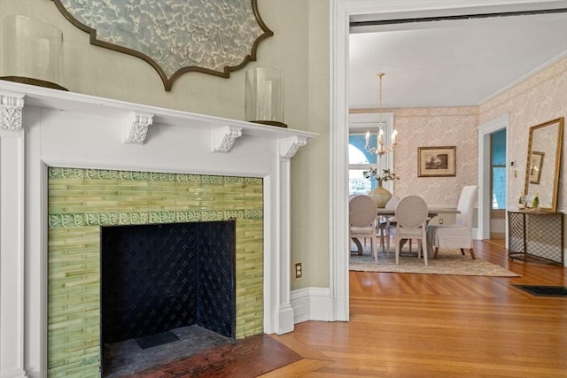 room details with an inviting chandelier, crown molding, wood finished floors, and wallpapered walls