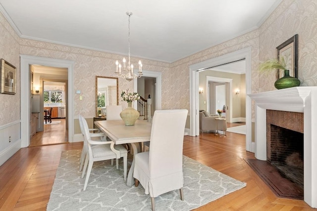 dining room featuring crown molding, wallpapered walls, and a notable chandelier