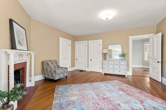 sitting room featuring baseboards, wood finished floors, and a fireplace