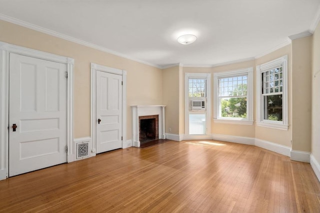 unfurnished living room featuring visible vents, crown molding, a fireplace, light wood-type flooring, and baseboards