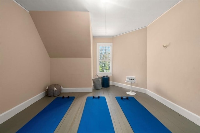 workout area with baseboards and wood finished floors