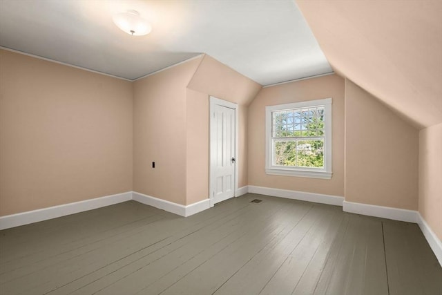 bonus room featuring baseboards, dark wood finished floors, and lofted ceiling