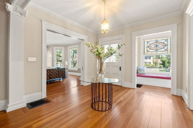 doorway to outside featuring ornamental molding, light wood-style flooring, and visible vents