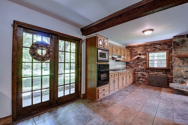 kitchen with radiator, plenty of natural light, french doors, and appliances with stainless steel finishes