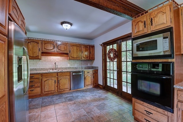 kitchen with tasteful backsplash, light stone counters, sink, and stainless steel appliances