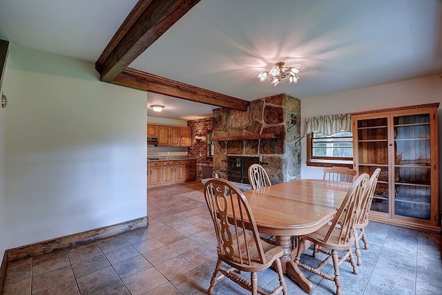 unfurnished dining area featuring a chandelier, a fireplace, and beamed ceiling