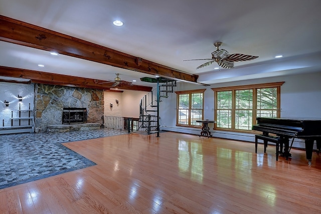 living room with beam ceiling, ceiling fan, a fireplace, and light hardwood / wood-style floors