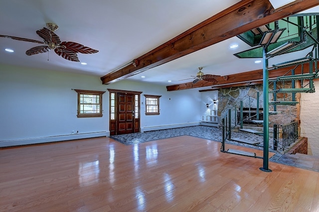 unfurnished living room featuring light hardwood / wood-style floors, a stone fireplace, beam ceiling, and a baseboard heating unit