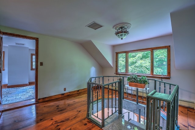 bonus room with hardwood / wood-style floors and a baseboard radiator