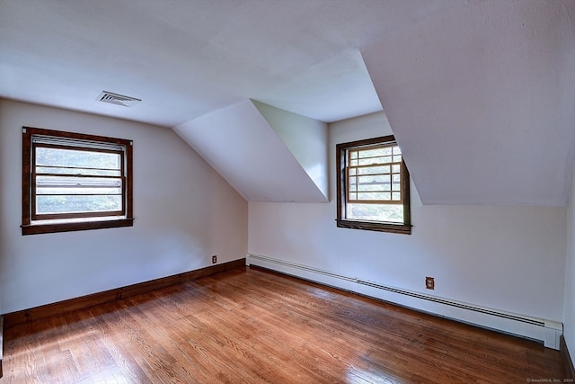 bonus room with wood-type flooring, a baseboard radiator, and vaulted ceiling