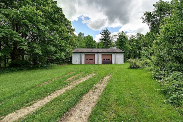 view of yard with a garage and an outbuilding