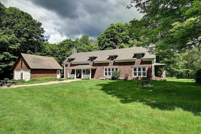 view of front of house with an outdoor structure and a front yard