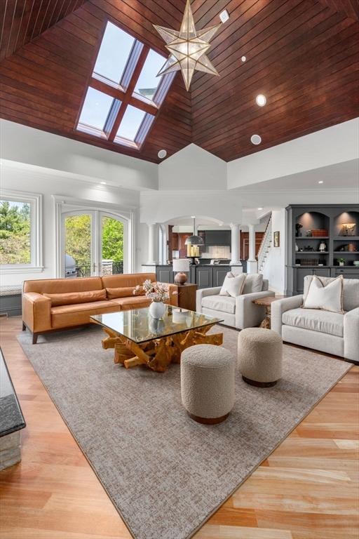 6 Wayside Cir, Framingham, MA 01701 - living room featuring a skylight, wood ceiling, high vaulted ceiling, wood finished floors, and ornate columns