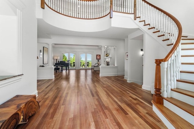 6 Wayside Cir, Framingham, MA 01701 - foyer featuring wood finished floors, a towering ceiling, stairs, decorative columns, and baseboards