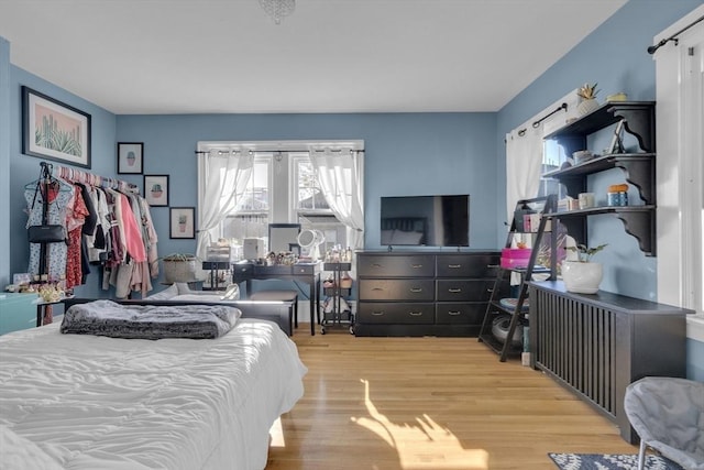 bedroom with a barn door and wood finished floors