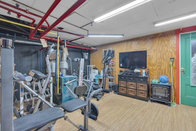 workout room featuring wood finished floors and wood walls