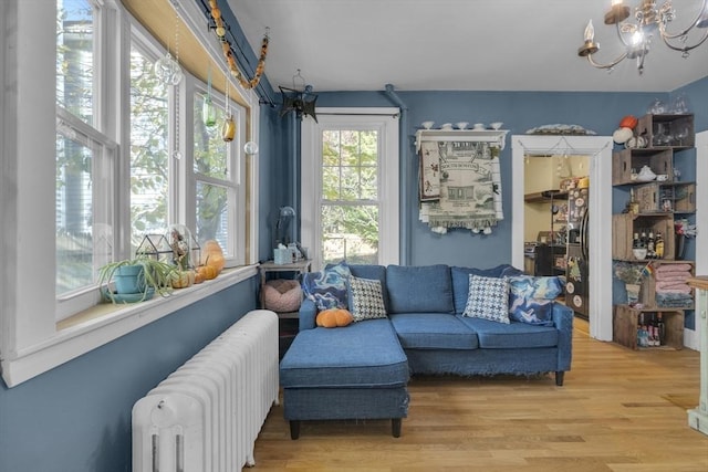 interior space with radiator heating unit, a notable chandelier, and light wood-style flooring