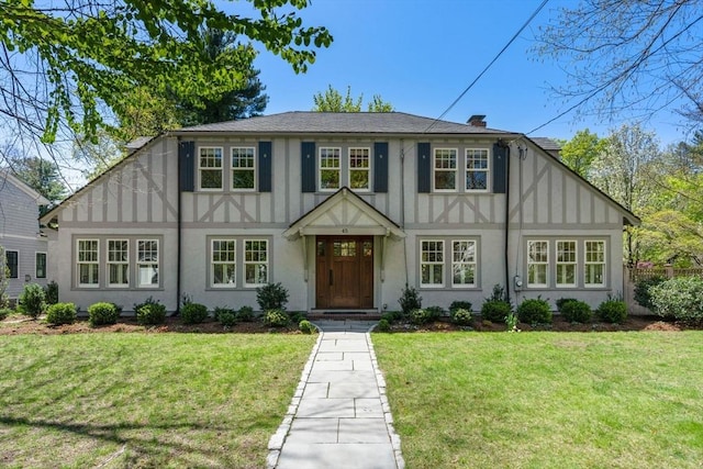 view of front facade with board and batten siding, stucco siding, and a front lawn