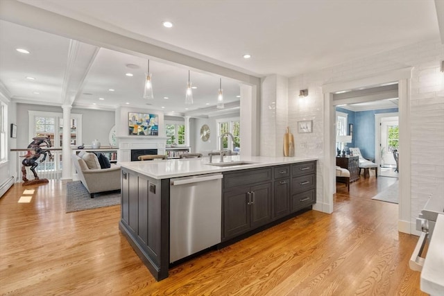 kitchen featuring a sink, light wood-style flooring, dishwasher, and a fireplace