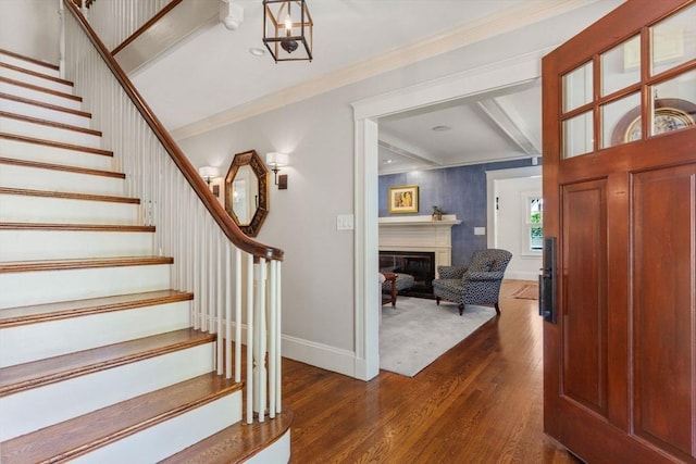 entryway with baseboards, dark wood-style flooring, crown molding, and stairway