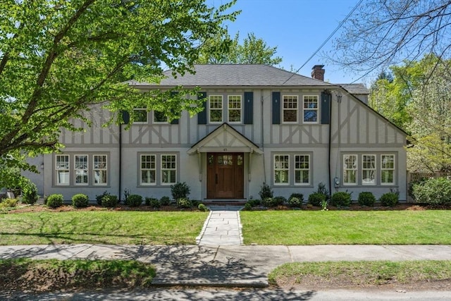 view of front of property with a front lawn, board and batten siding, stucco siding, and a chimney