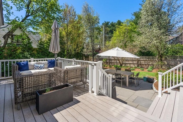 deck with an outdoor living space, a fenced backyard, and outdoor dining space