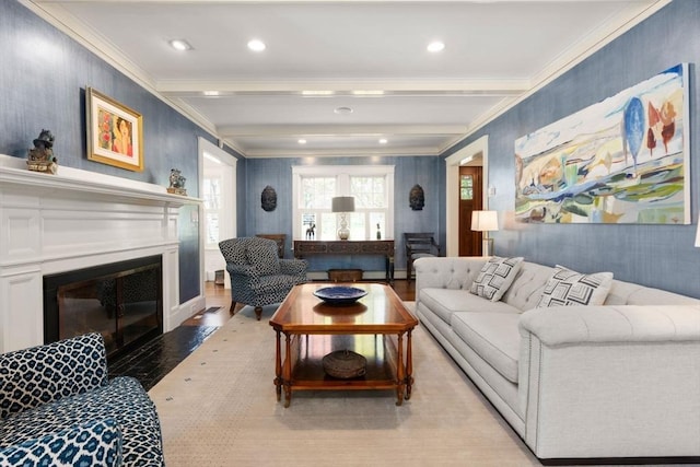 living area with crown molding, a fireplace with flush hearth, light wood-style flooring, and beam ceiling